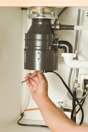 Plumber repairs a garbage disposal